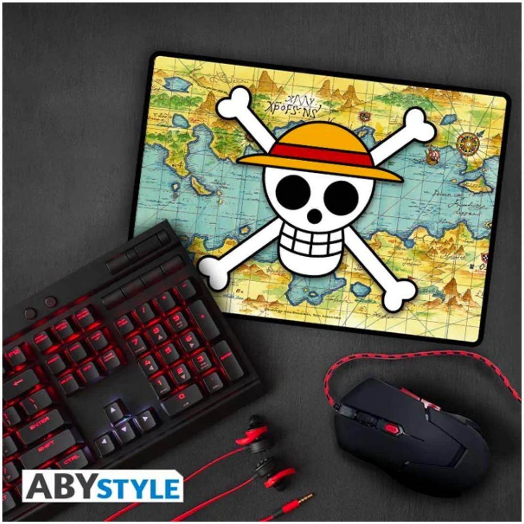 One Piece ABYstyle gaming mousepad featuring Straw Hat Pirates jolly roger logo on colorful Grand Line world map background, shown with gaming keyboard and mouse, official anime merchandise for fans and gamers.
