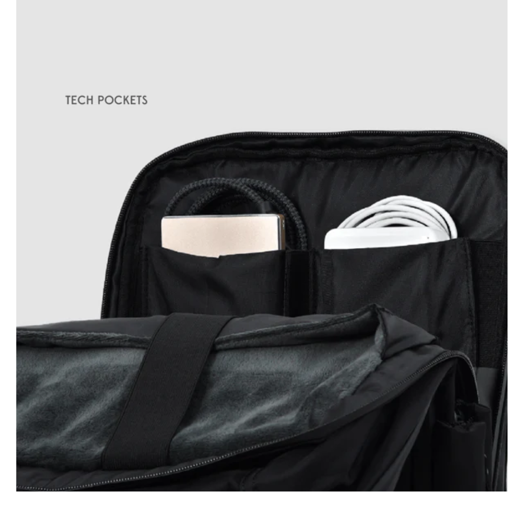 Close-up of black backpack interior showing tech pockets neatly storing a portable hard drive, charging cable, and accessories for organized travel or daily use.