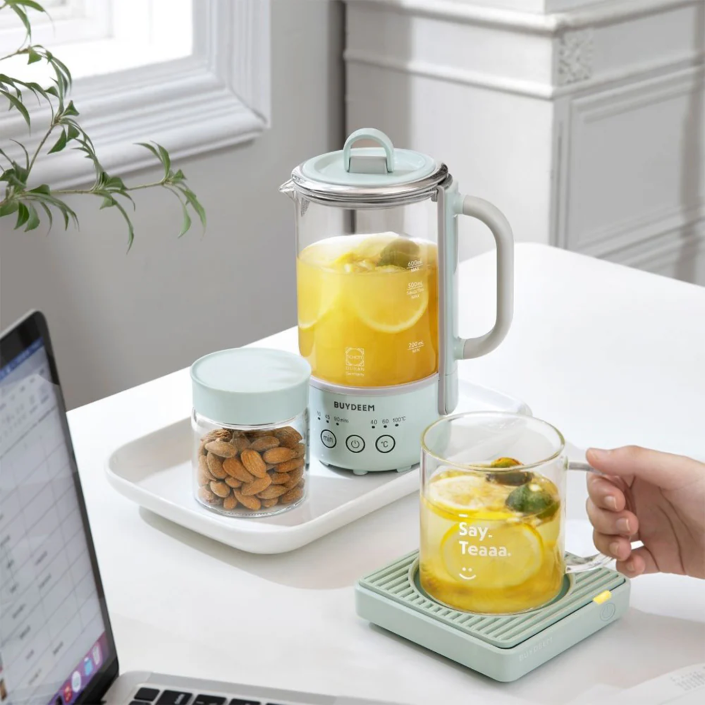 Buydeem Mini Health Pot Kettle Cooker on office desk brewing lemon tea, ideal for workspace or home use