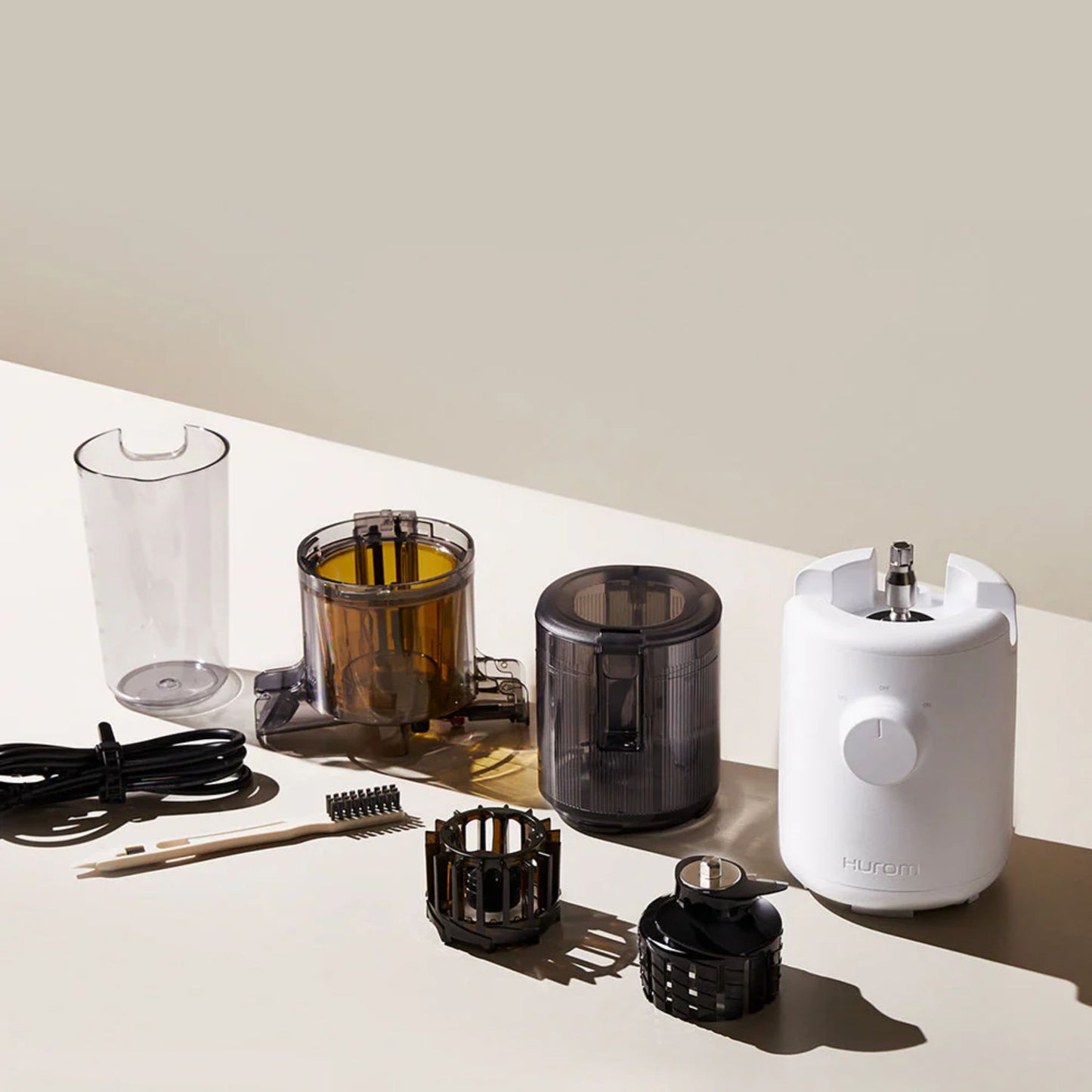 Hurom H310A Slow Juicer white model with all accessories, including chamber, hopper, multi-screw, cleaning brush, cord, and detachable parts displayed