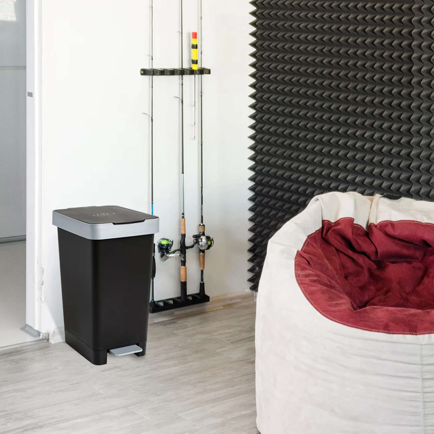 Modern room interior with Tatay 25L smart pedal bin in black and grey beside a bean bag, showing stylish hands‑free rubbish disposal.