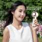 Woman using a portable bladeless handheld fan with digital display, enjoying outdoor cooling with 100-level stepless wind control, perfect for summer comfort and travel.