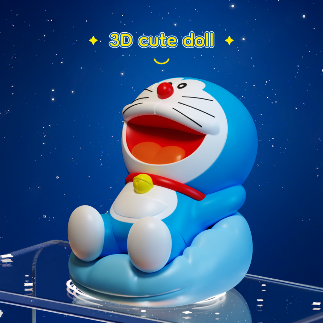 3D Doraemon cute doll figure with open mouth and red collar, sitting on a blue cushion against a starry night sky background, with "3D cute doll" text above