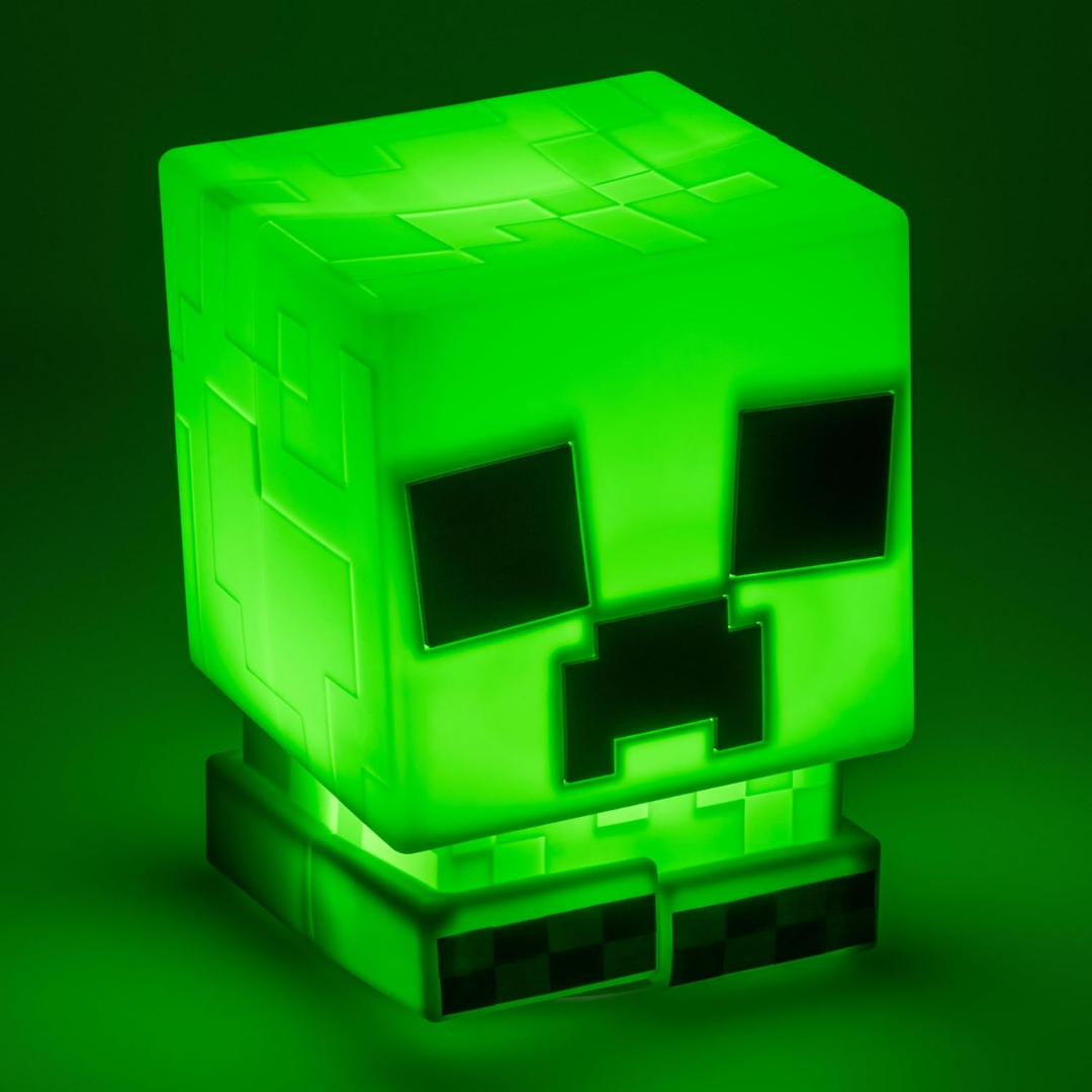 Paladone Minecraft Creeper SquishyGlo glowing green on a dark bedside table