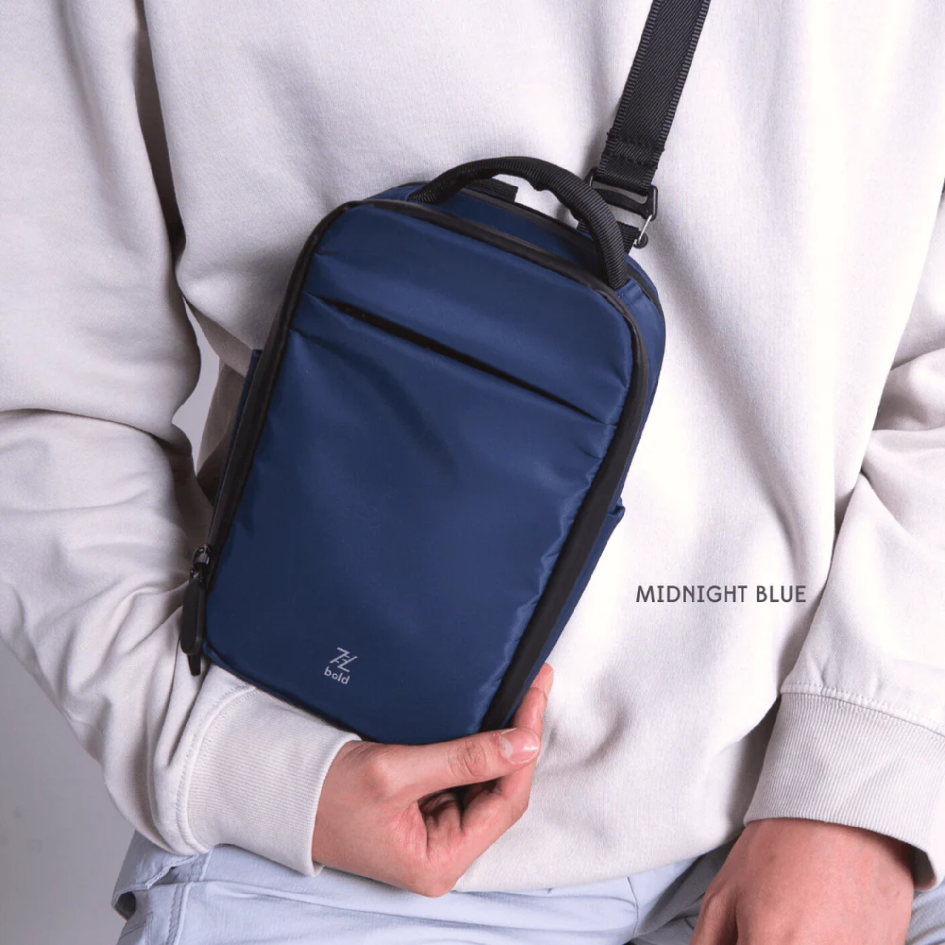 Bold Mimic Sling Bag in midnight blue, worn crossbody style by model; sleek, versatile bag for active urban and travel lifestyles.