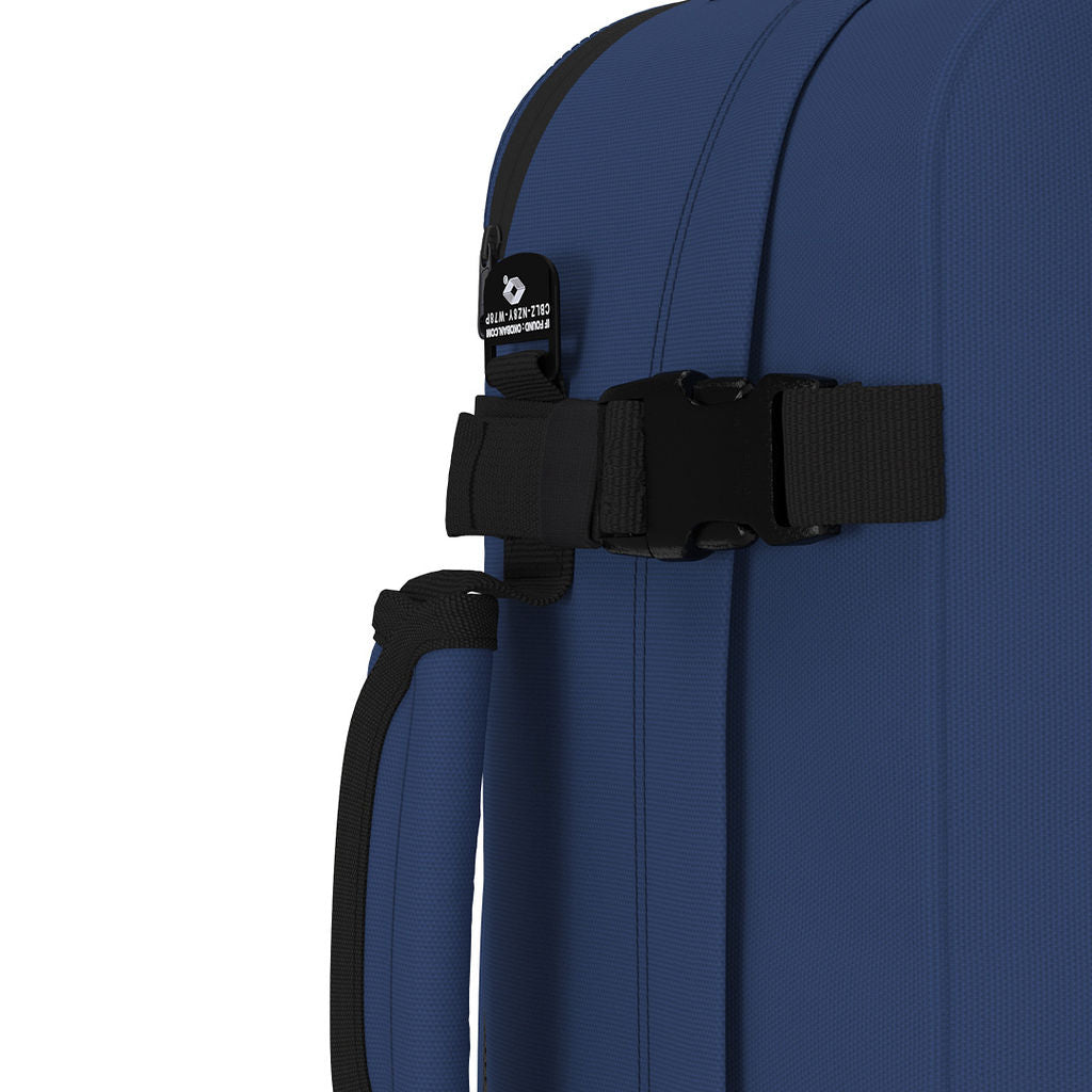 Close-up of CabinZero Classic Tech Bag 28L in Navy Blue showing compression strap, Tracer tag, and padded side handle for secure and comfortable carrying on travel or day-to-day use.