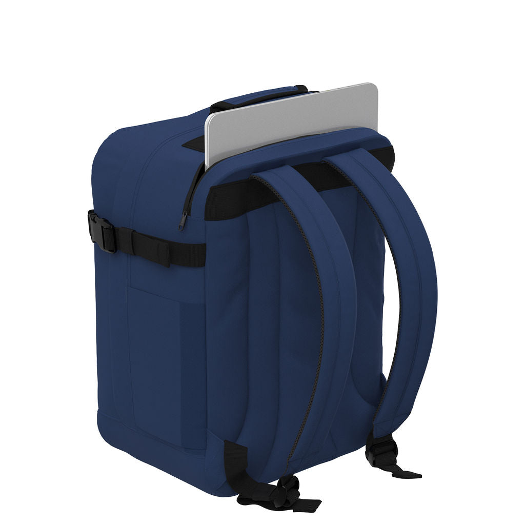 CabinZero Classic Tech Bag 28L in Navy Blue showing dedicated rear laptop compartment and padded shoulder straps for safe tech storage and comfortable commuting or travel