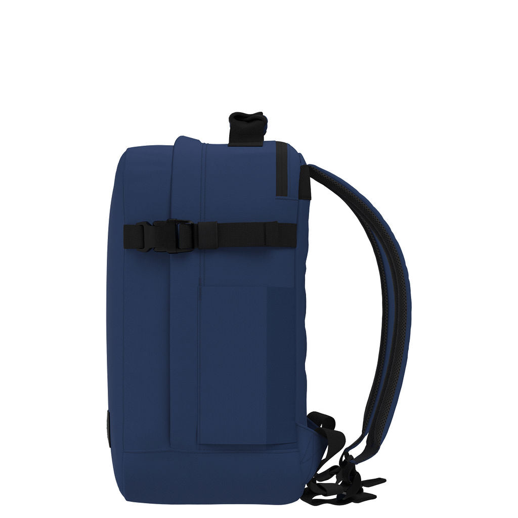 Profile view of CabinZero Classic Tech Bag 28L in Navy Blue featuring slim design, adjustable compression strap, and ergonomic shoulder straps—ideal for tech essentials, commuting, and travel comfort.