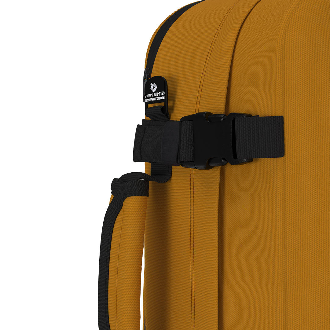 Close-up of CabinZero Classic Tech Bag 28L in Orange Chill showing the compression strap, Tracer tag, and padded side handle for secure, comfortable, and flexible carrying on travel or daily commutes