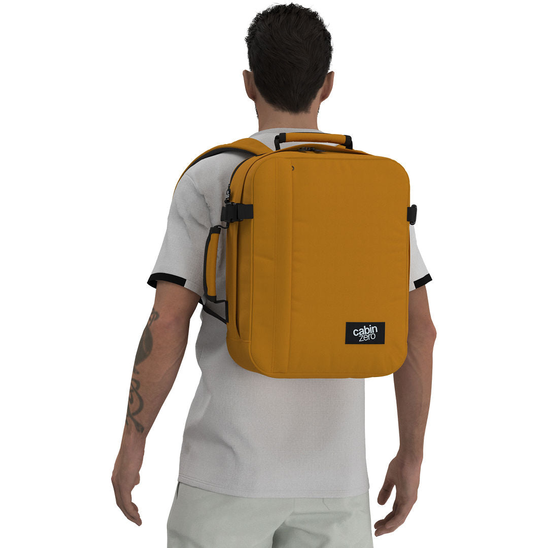 Man wearing CabinZero Classic Tech Bag 28L in Orange Chill, showcasing ergonomic shoulder straps and a minimalist silhouette—ideal for tech-savvy travelers, daily commutes, and organized packing.