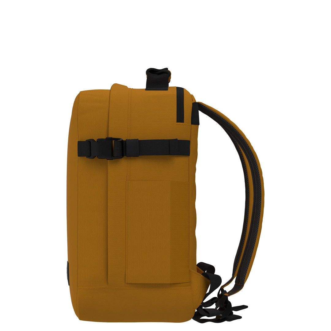 Profile view of CabinZero Classic Tech Bag 28L in Orange Chill showing slim shape, adjustable compression strap, and ergonomic shoulder straps—ideal for tech commuters and efficient travel organization