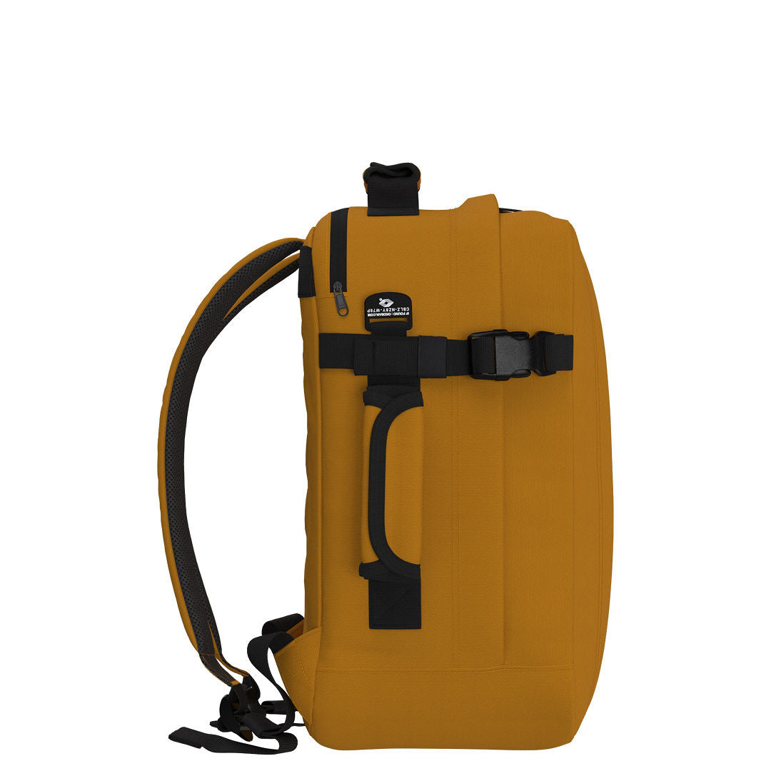 Side view of CabinZero Classic Tech Bag 28L in Orange Chill showing padded side handle, compression strap, and Tracer tag—perfect for secure, versatile, and comfortable carry during tech travel and daily use