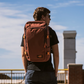 CabinZero ADV Pro 32L backpack in Saigon Coffee brown used outdoors, stylish travel bag with padded straps and compression for city adventures
