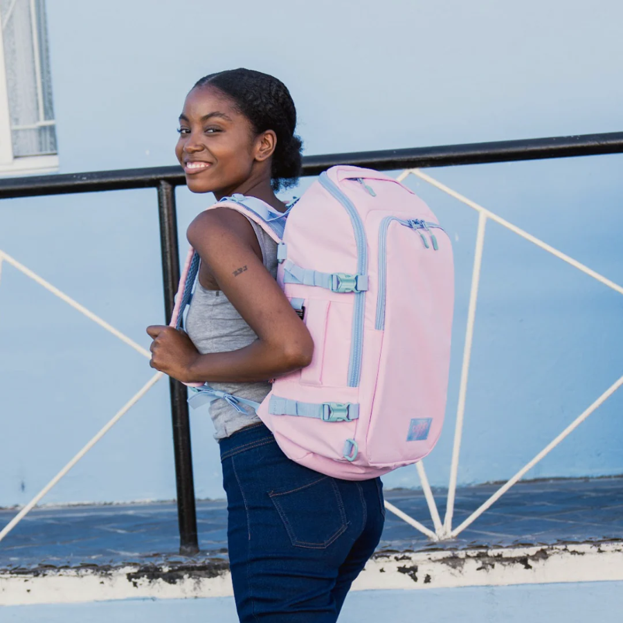 CabinZero ADV Pro 32L backpack in Sakura Pink worn outdoors, lightweight travel bag with padded straps and side compression for stylish adventures