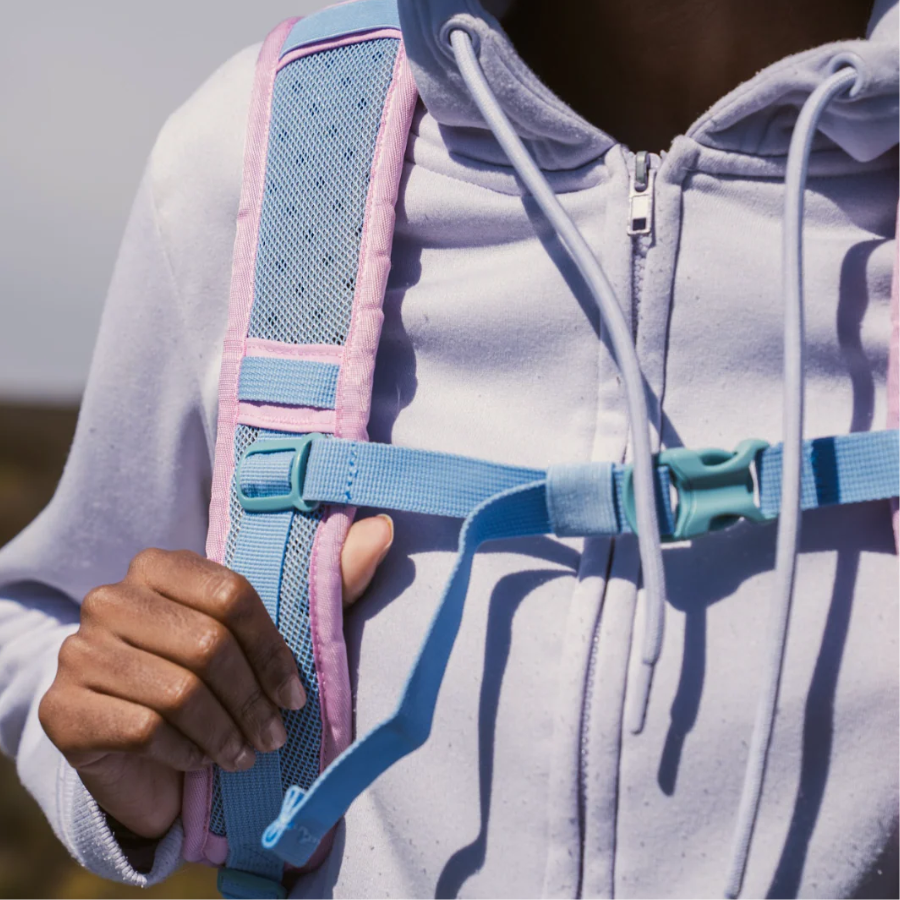 Close-up of CabinZero ADV Pro 32L Sakura Pink backpack shoulder strap and chest buckle, showing padded ergonomic design and adjustable fit for comfortable travel