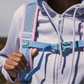 Close-up of CabinZero ADV Pro 32L Sakura Pink backpack shoulder strap and chest buckle, showing padded ergonomic design and adjustable fit for comfortable travel