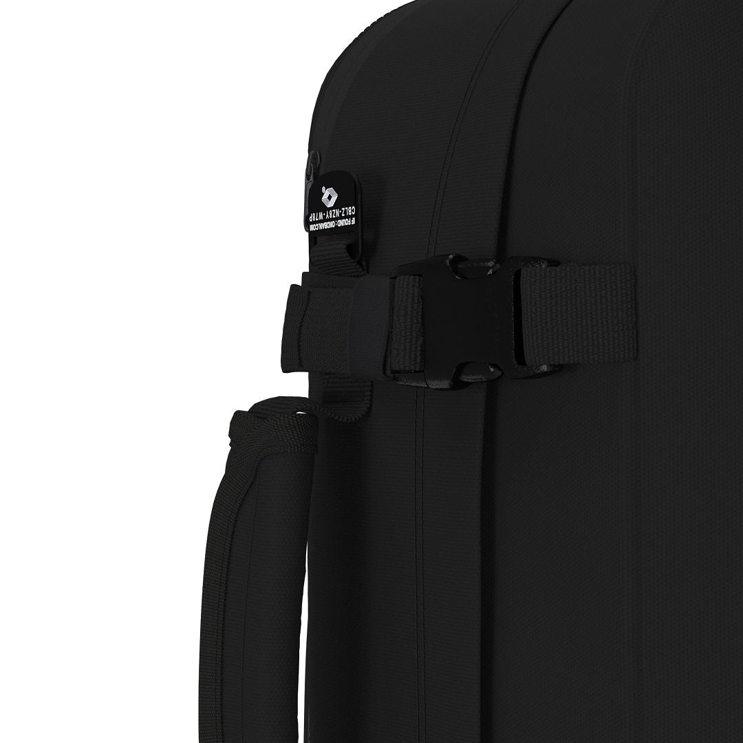 Close-up of CabinZero Classic Tech Bag 28L in Absolute Black showing compression strap, Tracer tag, and padded side handle for extra security and convenience during travel.