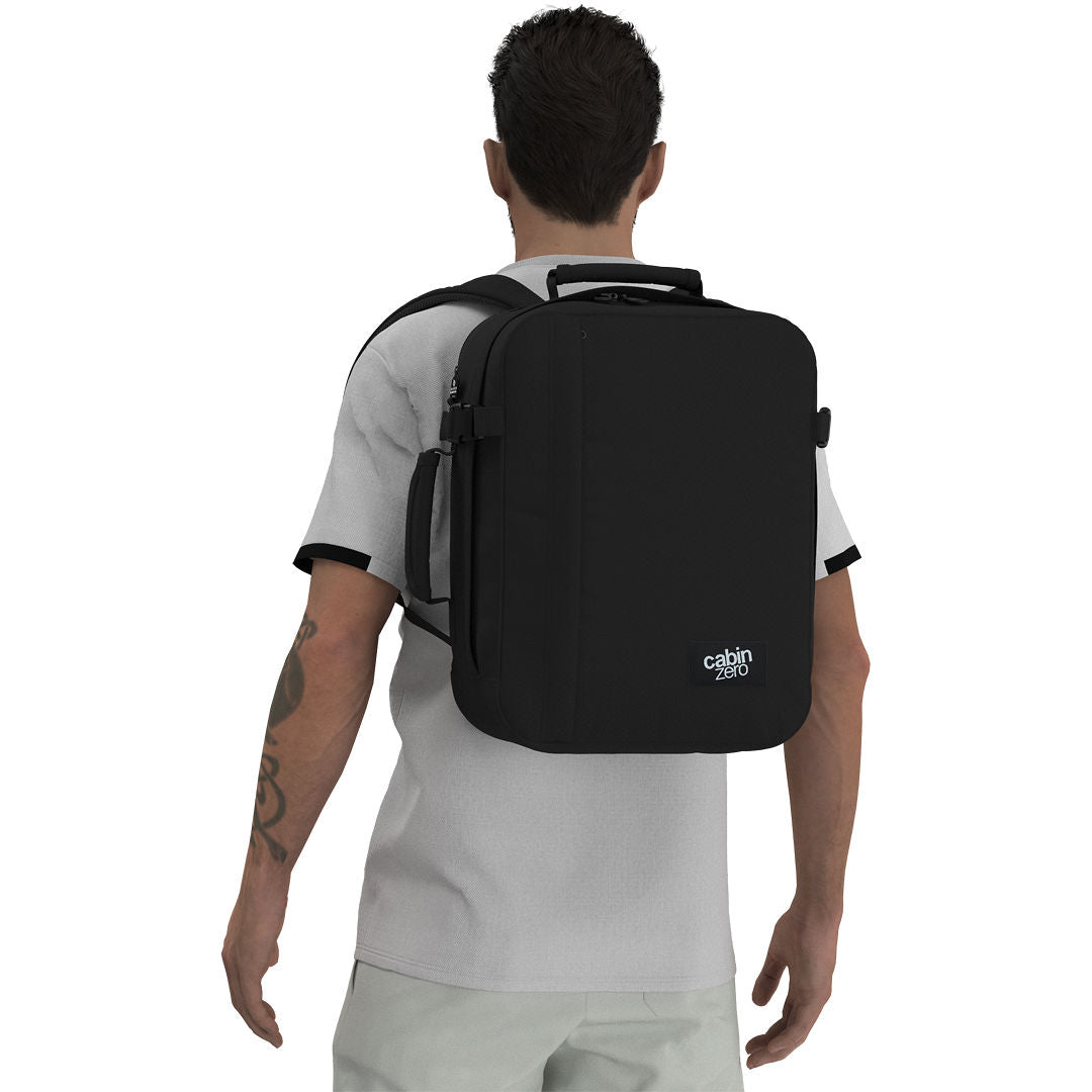 Man wearing CabinZero Classic Tech Bag 28L in Absolute Black, highlighting ergonomic shoulder straps and padded back panel—perfect for travel, work, and tech commuters.