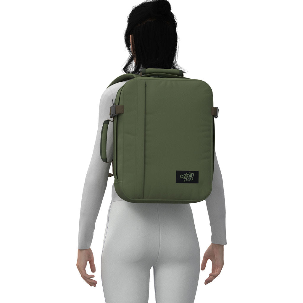 Woman wearing CabinZero Classic Tech Bag 28L in Georgian Khaki, highlighting padded straps and ergonomic fit—ideal backpack for stylish tech commuters, travel, and everyday organization.