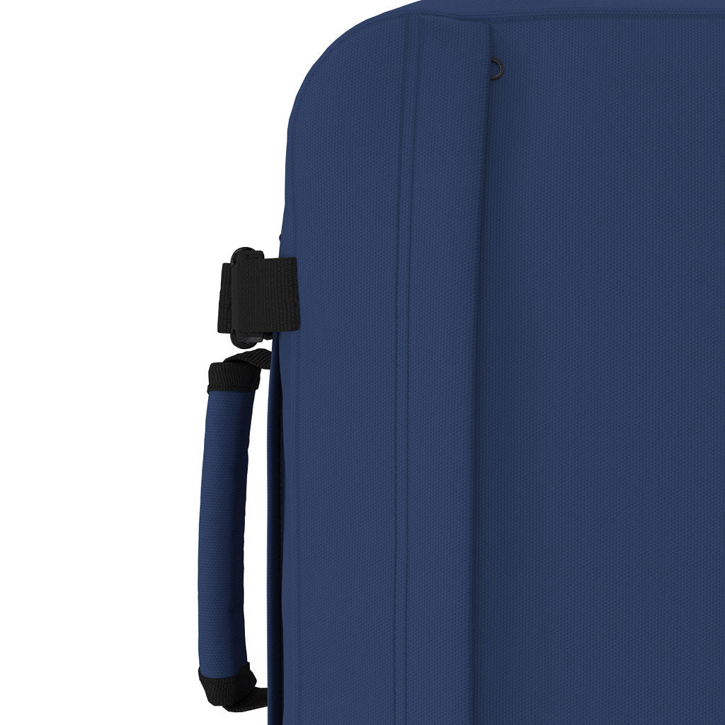 Detail view of CabinZero Classic Tech Bag 28L in Navy Blue showing padded side handle and compression strap—designed for flexible, comfortable carrying on trips and commutes