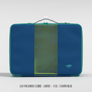 Front view of a large CabinZero Lux Packing Cube in Capri Blue with a central mesh panel, double zipper closure, top handle, and the CabinZero logo in the lower right corner.