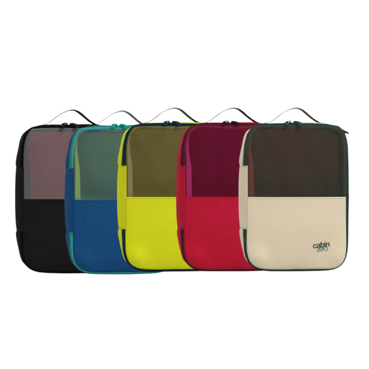 Five CabinZero Lux Packing Cubes in large size, arranged in a row, each in a different color: black, blue, yellow, red, and beige. Each cube features a mesh upper panel, double zipper closure, and a top handle.