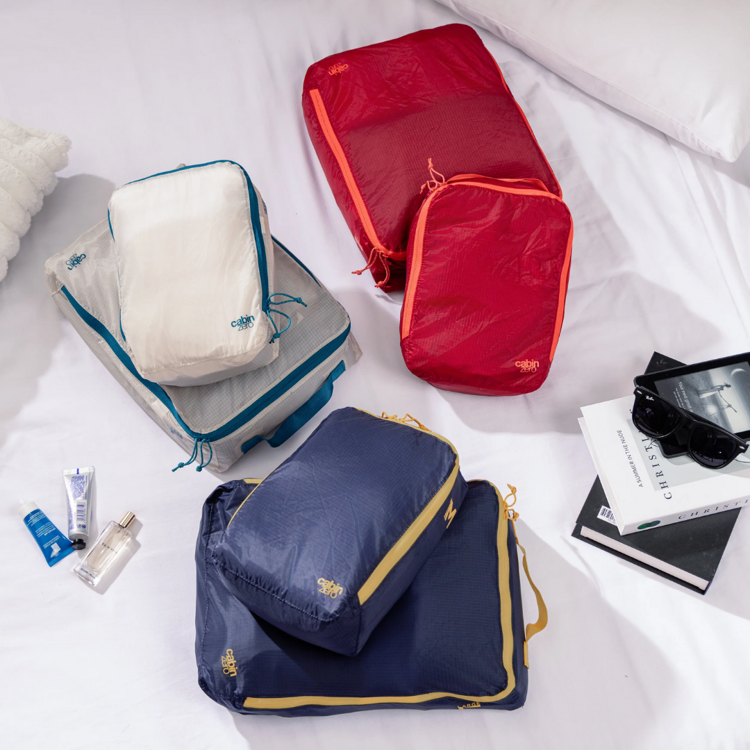 CabinZero ULTRALIGHT PACKING CUBE Medium 5.5L in Fiesta Red, Blue Shimmer, and Oyster White—lightweight travel organizers shown packed and ready for use