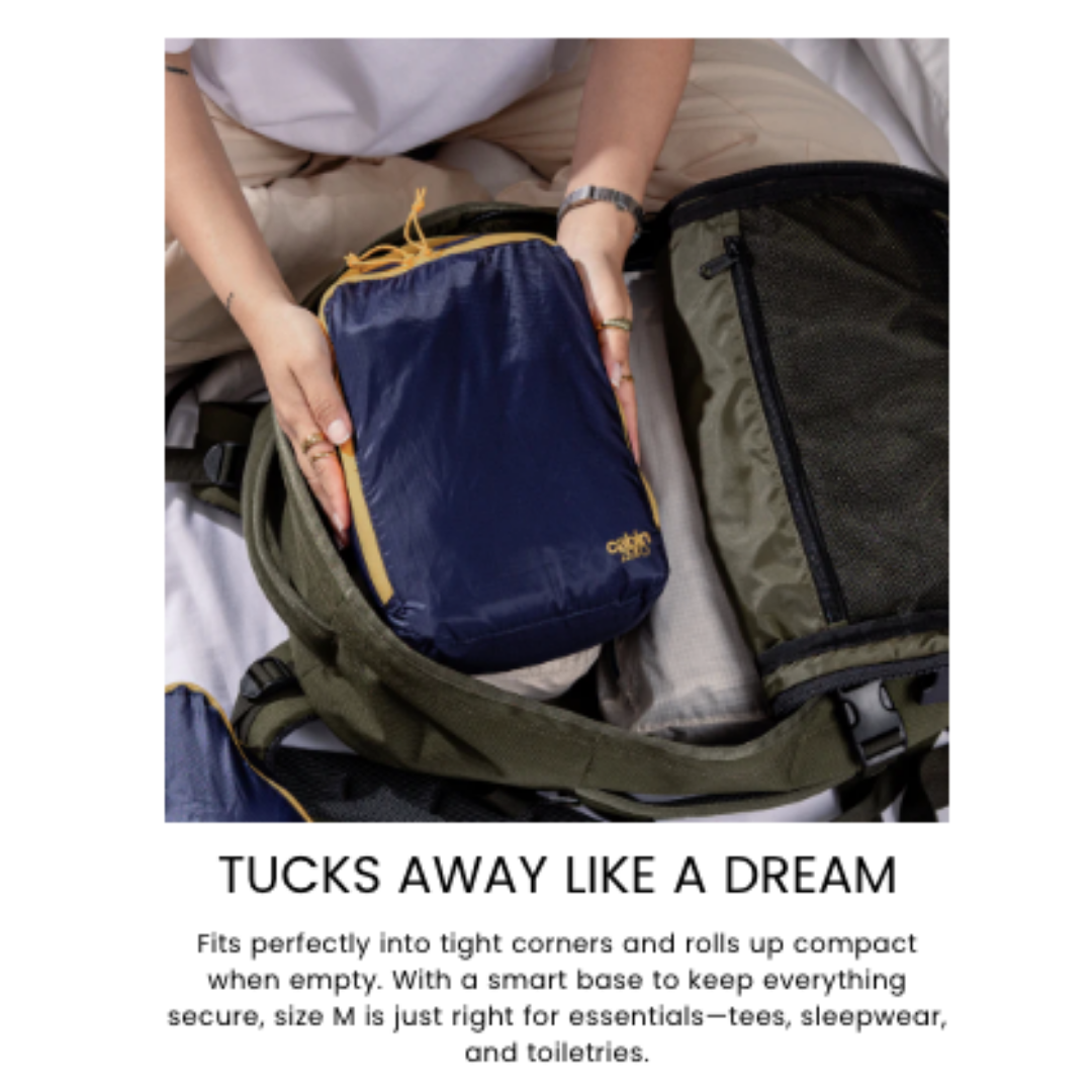 CabinZero ULTRALIGHT PACKING CUBE Medium 5.5L Blue Shimmer being packed—compact, ultralight, easy-to-store organizer for travel essentials and toiletries.
