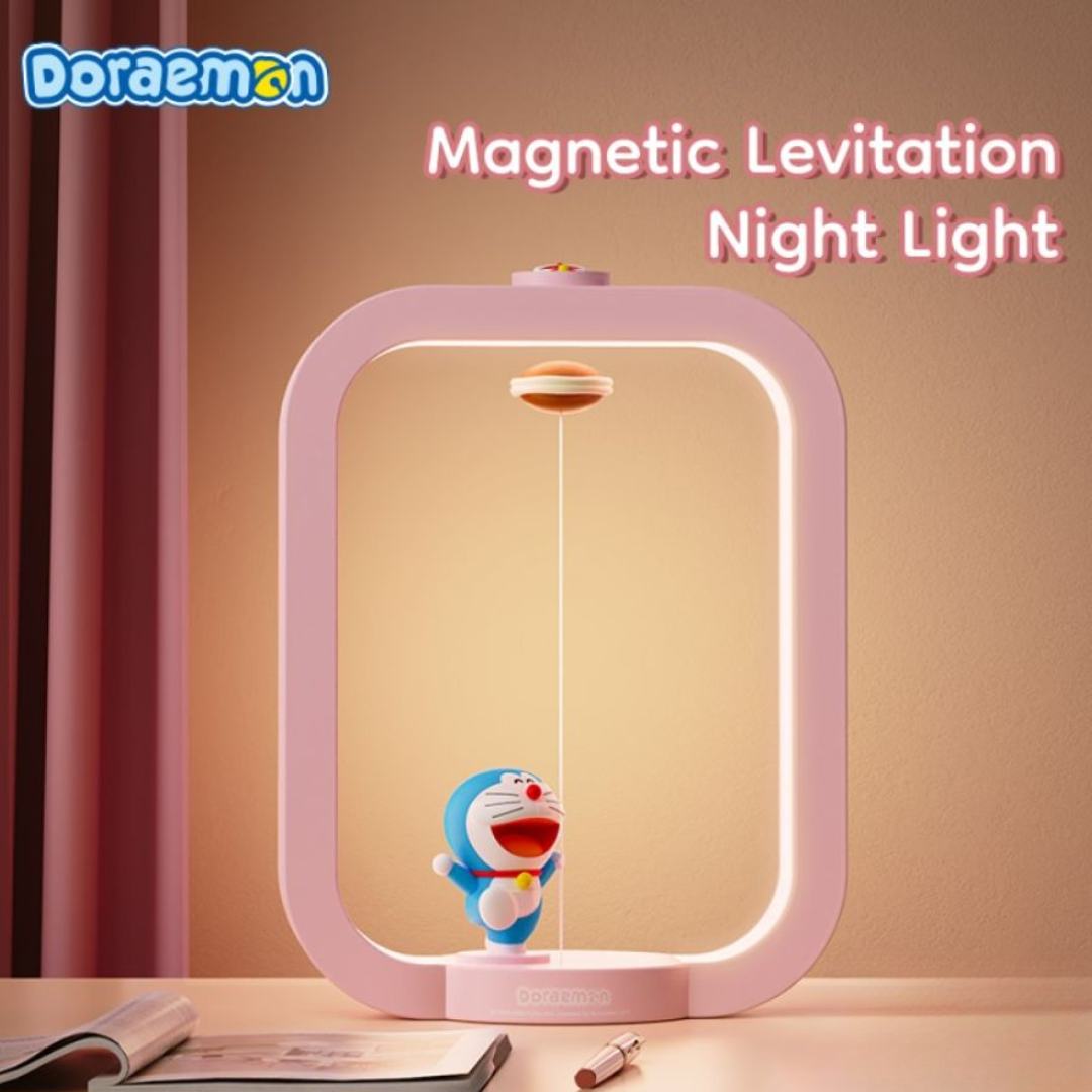 Pink Doraemon magnetic levitation night light with floating dorayaki and smiling Doraemon figure, set on a desk with warm ambient lighting and "Magnetic Levitation Night Light" text in the background