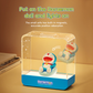 Doraemon Starry Night Light with magnetic sofa, featuring a smiling Doraemon doll seated inside a transparent rectangular lamp that illuminates when the doll is placed, on a bedside table with books
