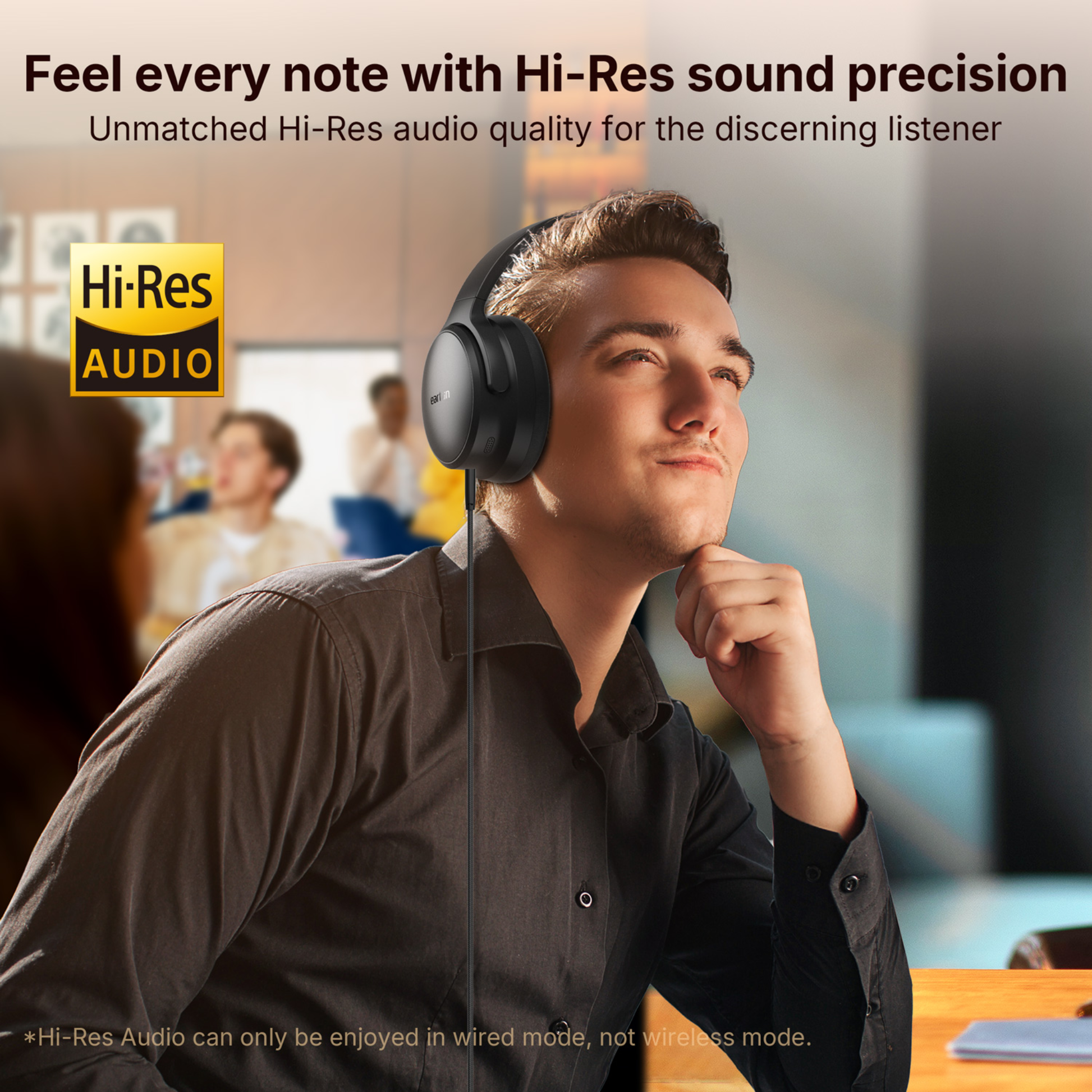 Man wearing black EarFun Tune Pro headphones with a wired connection, looking thoughtful in a modern indoor setting, with Hi-Res Audio logo and text promoting Hi-Res sound precision for discerning listeners.