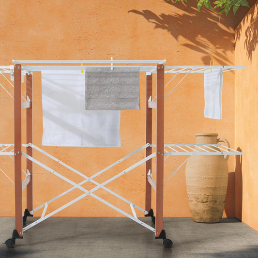Foppapedretti Gulliver Beechwood Drying Rack with foldable design and wheels, set up outdoors with towels and laundry hanging