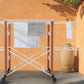 Foppapedretti Gulliver Beechwood Drying Rack with foldable design and wheels, set up outdoors with towels and laundry hanging