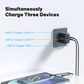 Griffin 70W GaN wall charger plugged in, simultaneously charging three devices with dual USB-C and one USB-A port, highlighting output wattages for each port.