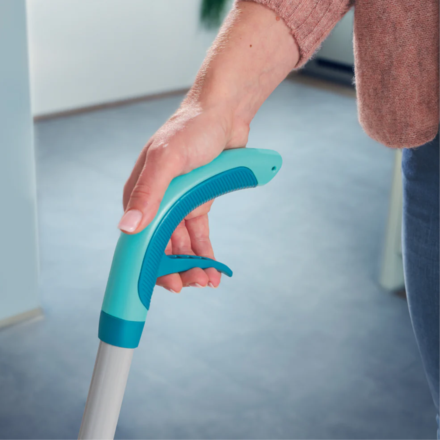 Close-up of ergonomic handle and trigger on Leifheit Comfort Easy Spray XL spray mop for controlled floor cleaning.