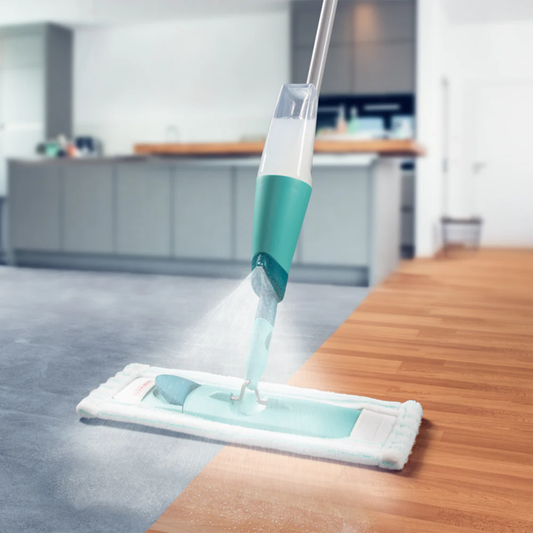 Leifheit Comfort Easy Spray XL mop spraying fine mist while cleaning both tile and wood floors in a modern kitchen.