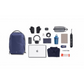 Flat lay of navy blue backpack and everyday essentials including laptop, headphones, gloves, water bottle, shirt, tech accessories, and snacks on a white background.