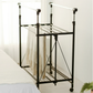 RENE Ocho expandable laundry drying rack in a bright bedroom with a beige blanket hanging over the middle bars and a lower wire shelf for extra drying space.