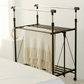 RENE Ocho expandable laundry drying rack in a bedroom holding a beige blanket, showing double bars and lower shelf for space-saving indoor clothes drying.