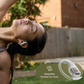 Person wearing Shokz open-ear wireless earbud doing yoga outdoors, highlighting adaptable flexible ear hook design