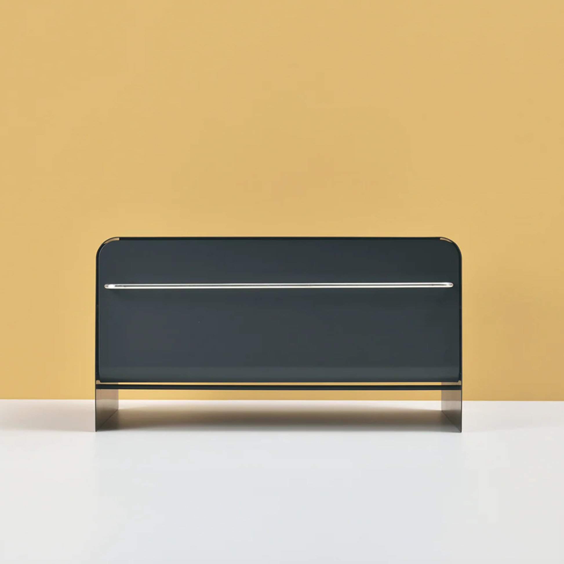 UtaU Bread Drawer in calm grey, modern steel bread storage box with chrome bar handle against mustard yellow wall on white countertop.