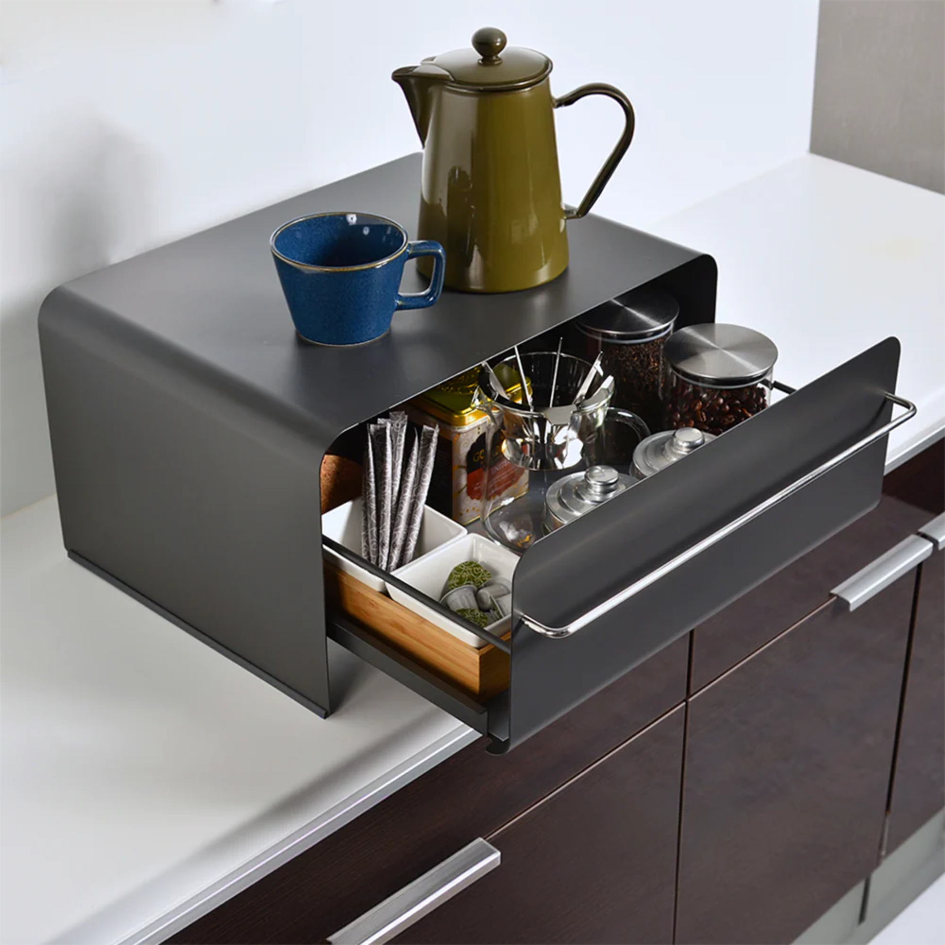 UtaU Bread Drawer in calm grey used as coffee station organiser, open drawer storing mugs, jars and accessories with kettle and cup on top.