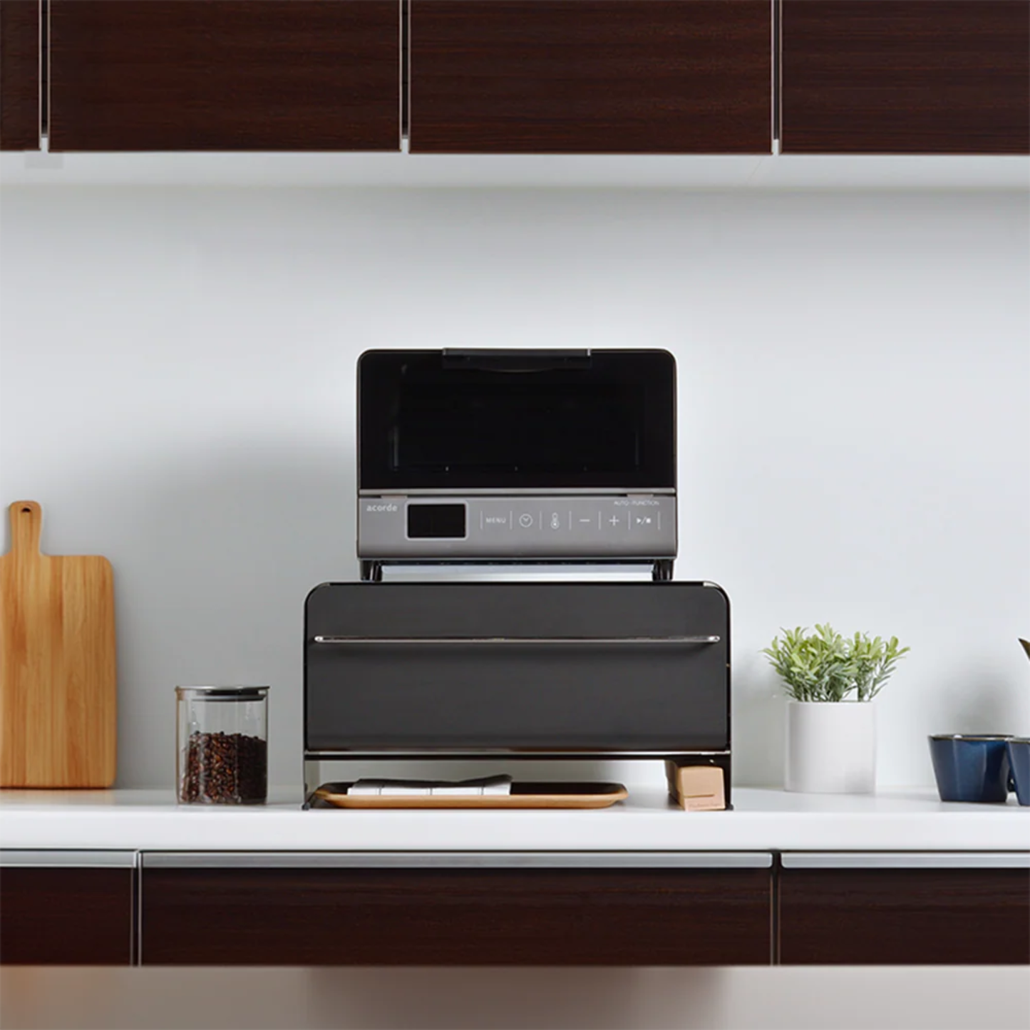 UtaU Bread Drawer in calm grey on modern kitchen counter, used as stand for compact black toaster oven with coffee beans jar and plant decor.