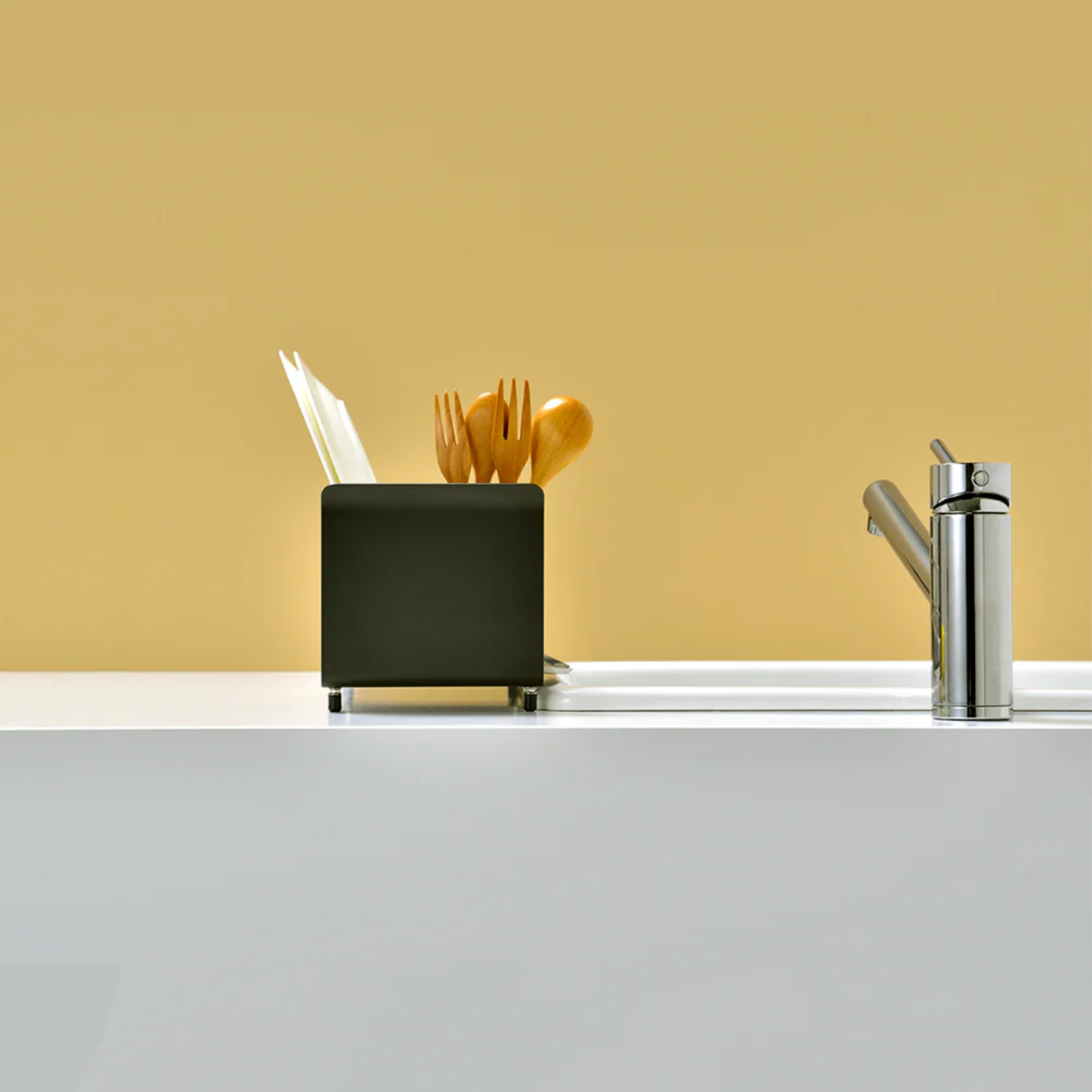 UtaU Dish Drainer Short calm gray utensil holder on modern kitchen countertop beside stainless steel sink tap, side view
