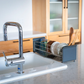 UtaU Dish Drainer Short calm gray over-the-sink rack holding plates, bowls, glasses and wooden utensils in modern kitchen