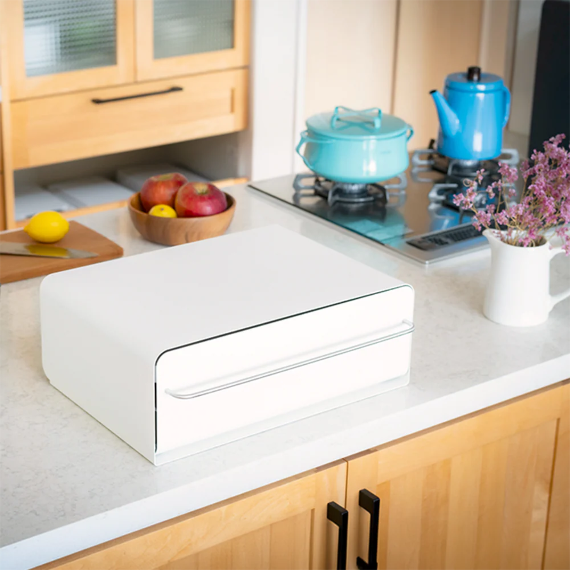 UtaU white counter drawer organizer on bright kitchen countertop beside stove, fruit bowl and flowers for clean storage