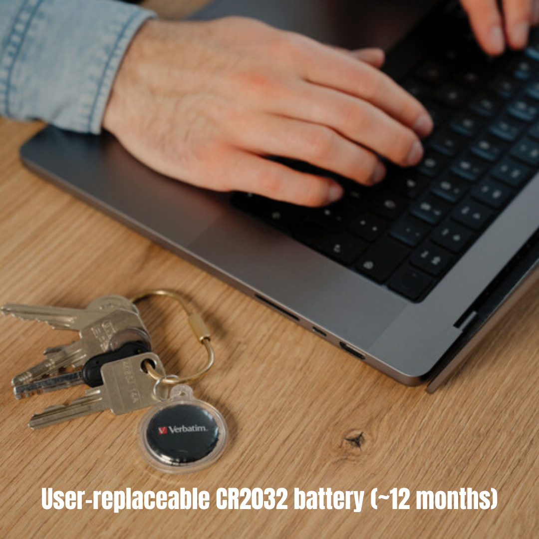 Verbatim Bluetooth coin tracker on a keyring, user-replaceable CR2032 battery, compatible with Apple Find My, next to a laptop keyboard