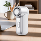 White WiWU Ice Core Mini Fan FS018 standing on a desk beside a laptop, showing compact design and front digital display for office or home use