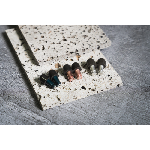 Attenu8 noise reduction earplugs in blue, rose gold, and silver colors displayed on stone textured surface for Ideale Lifestyle e-commerce store