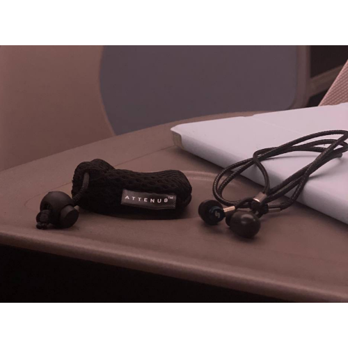 Attenu8 noise reduction earplugs with mesh carry pouch and lanyard shown on desk, ideal for portability and everyday use, available at Ideale Lifestyle e-commerce store